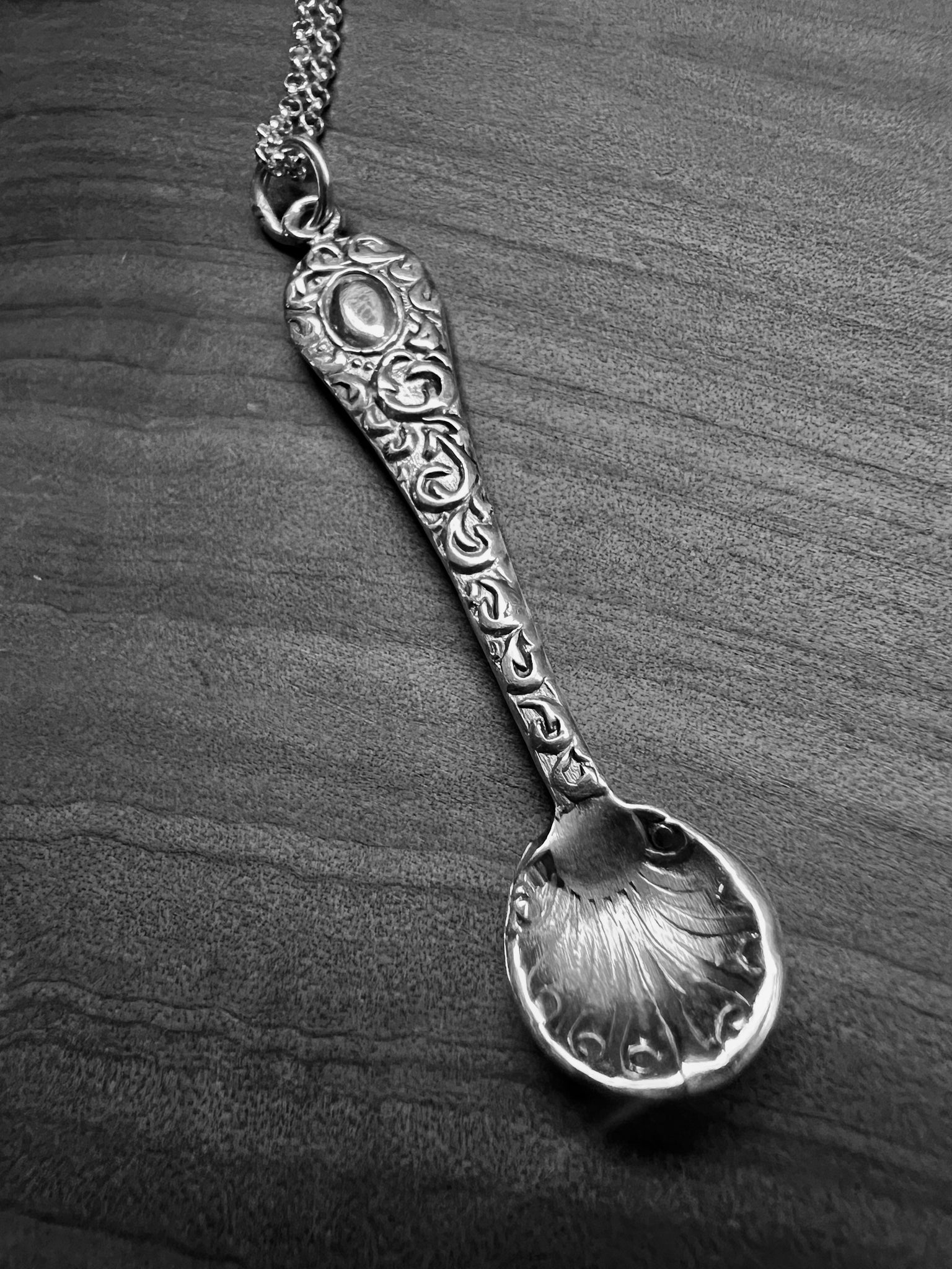 A tiny silver ornate salt spoon pendant upon sterling belcher chain