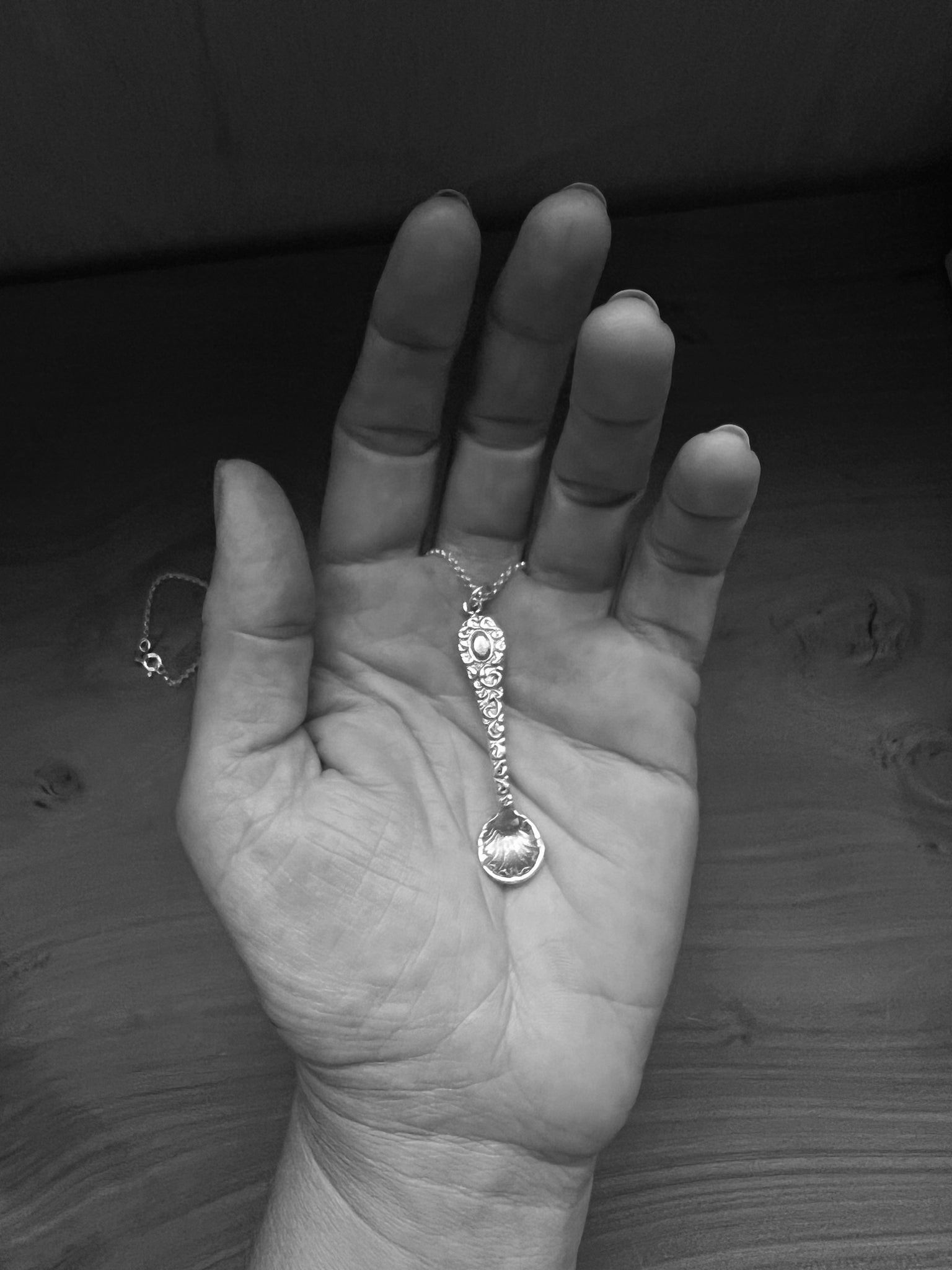 A tiny silver ornate salt spoon pendant upon sterling belcher chain